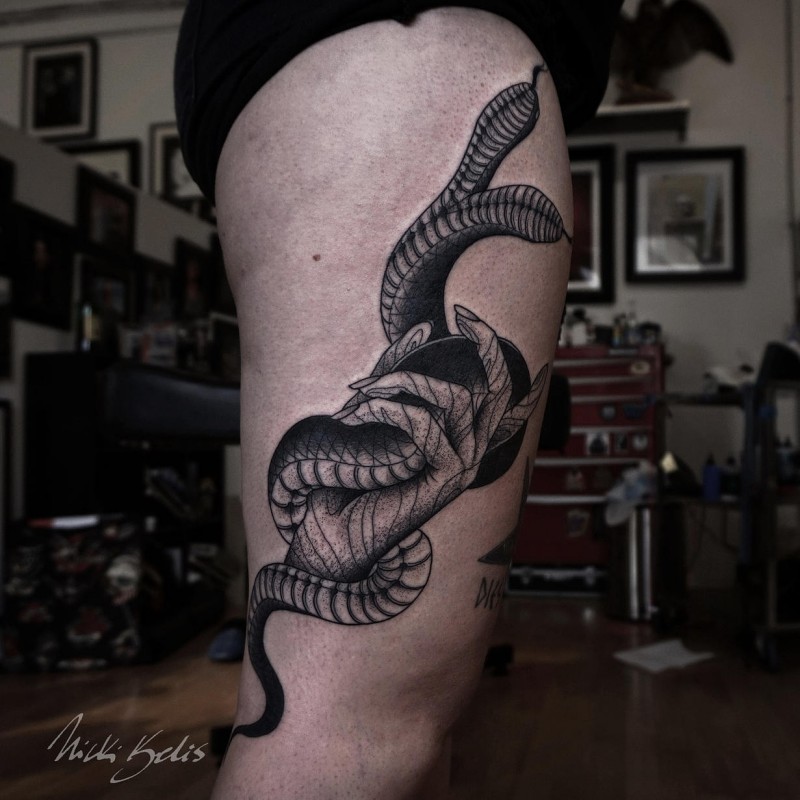 Old school engraving style black ink thigh tattoo of human hand with snakes