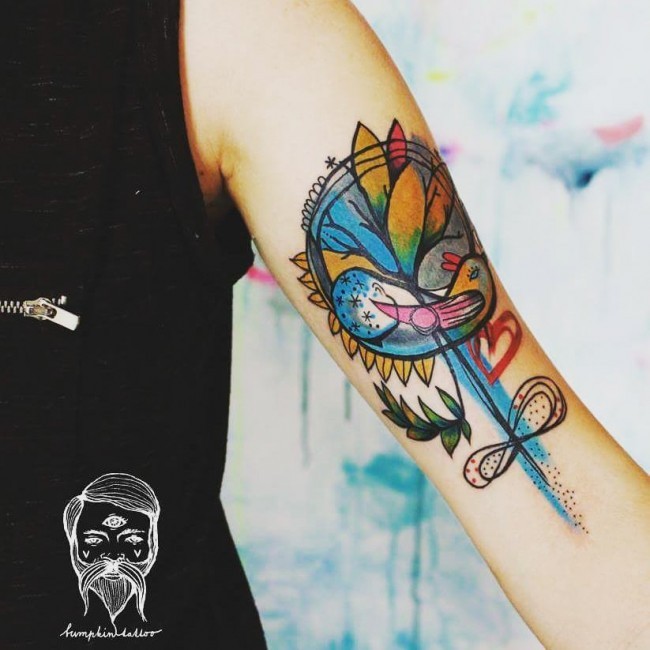 Old school flower shaper tattoo on arm stylized with bow and birds
