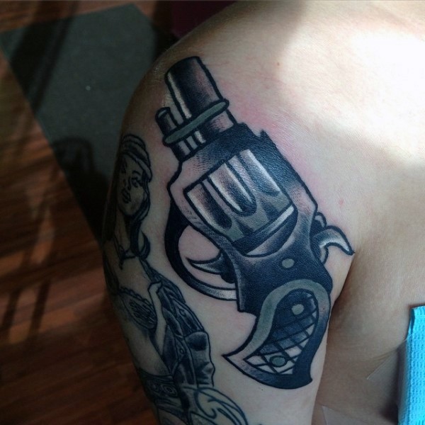 Old school funny looking small shoulder tattoo of lady pistol