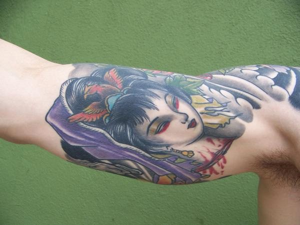 Old school multicolored bloody Geisha head tattoo on biceps