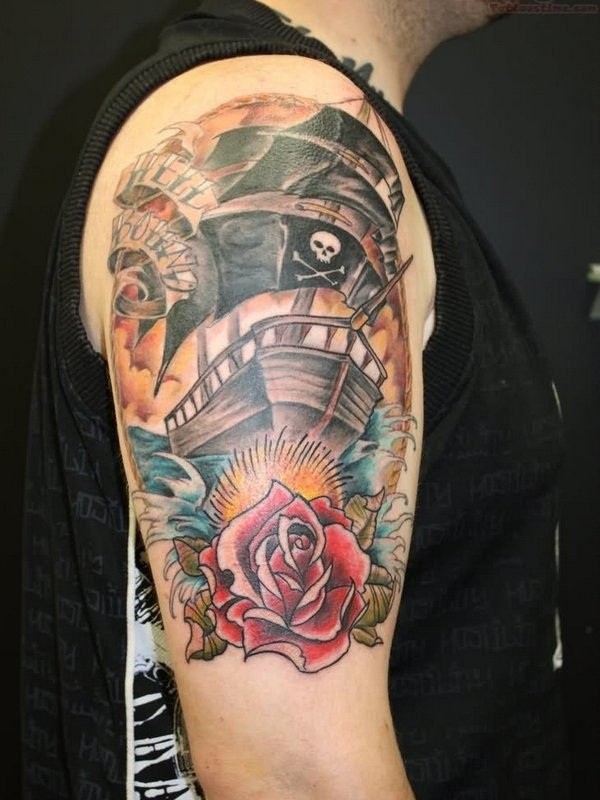 Old school nautical themed on shoulder tattoo of pirate ship with rose and lettering