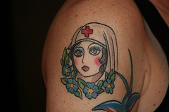 Old school shoulder tattoo with nurse and flowers