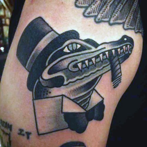 Tatuaje en el brazo,
caimán caballero divertido en sombrero de copa