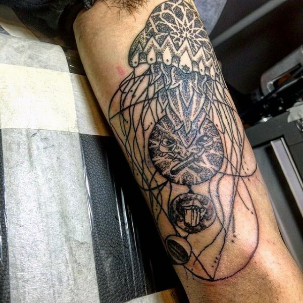 Tatuaje en el brazo,
medusa estilizada y bellotas pequeñas