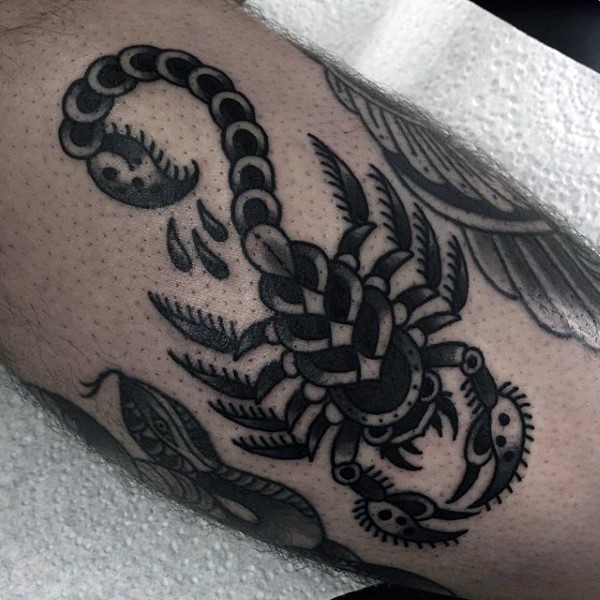 Old school style black and white little scorpion tattoo on leg