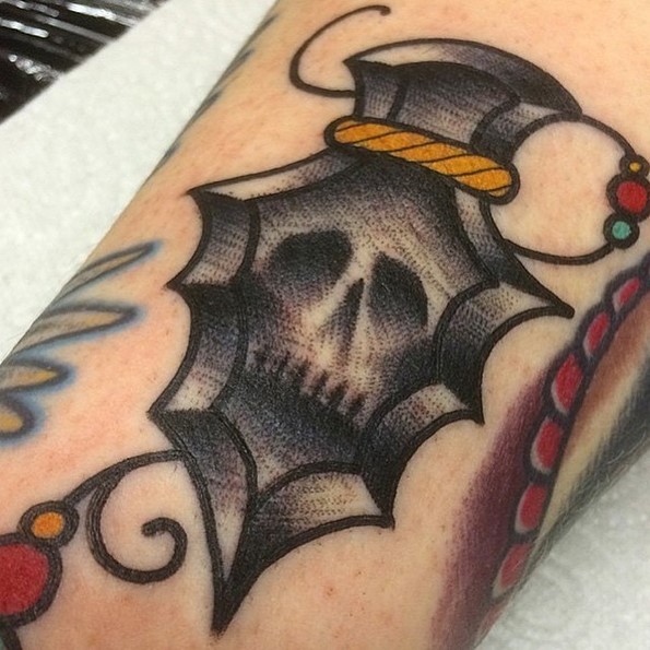Old school style black ink colored ancient weapon forearm tattoo stylized with skull