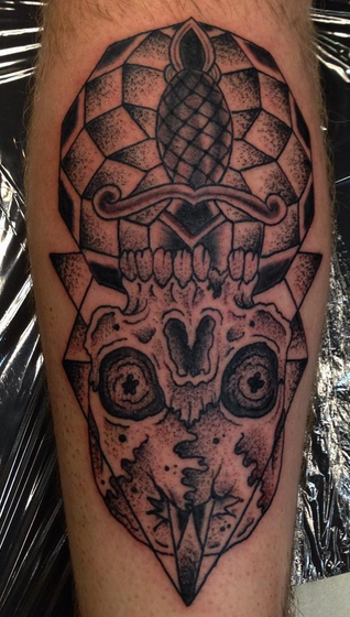 Old school style black ink leg tattoo of creepy skull with dagger