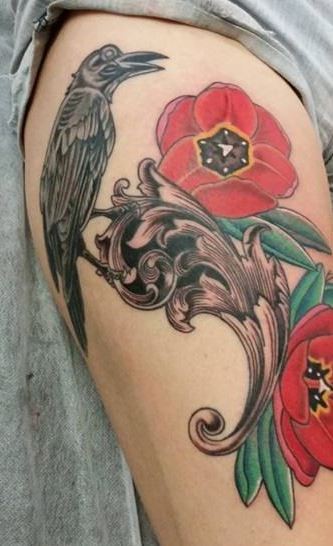 Old school style black ink natural looking crow tattoo on thigh with flowers