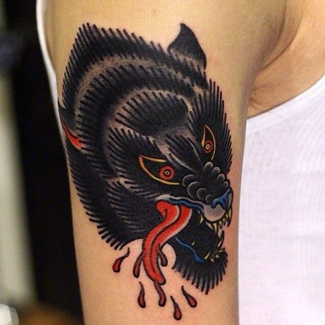 Old school style black wolf's head with bloody drops colored shoulder tattoo