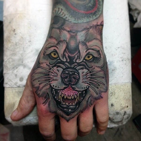 Tatuaje en la mano, 
cara de lobo furioso amenazante, estilo old school