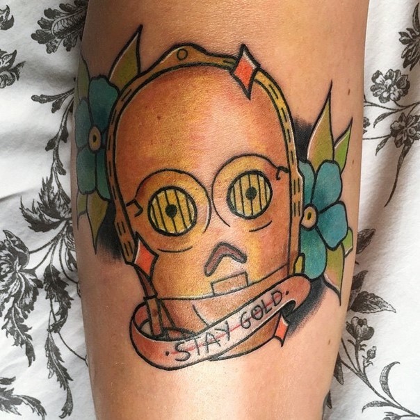 Old school style colored C3PO tattoo on forearm with lettering and flowers