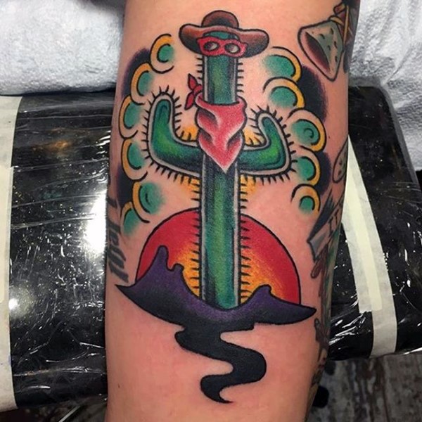 Old school style colored cowboy like cactus tattoo on arm