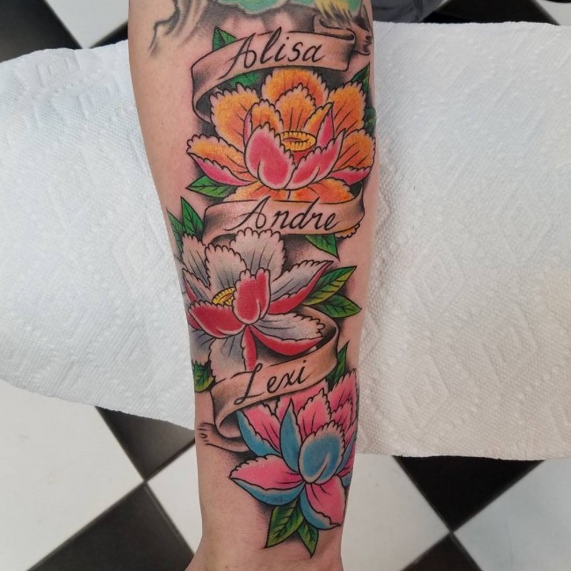 Old school style colored forearm tattoo of flowers and lettering