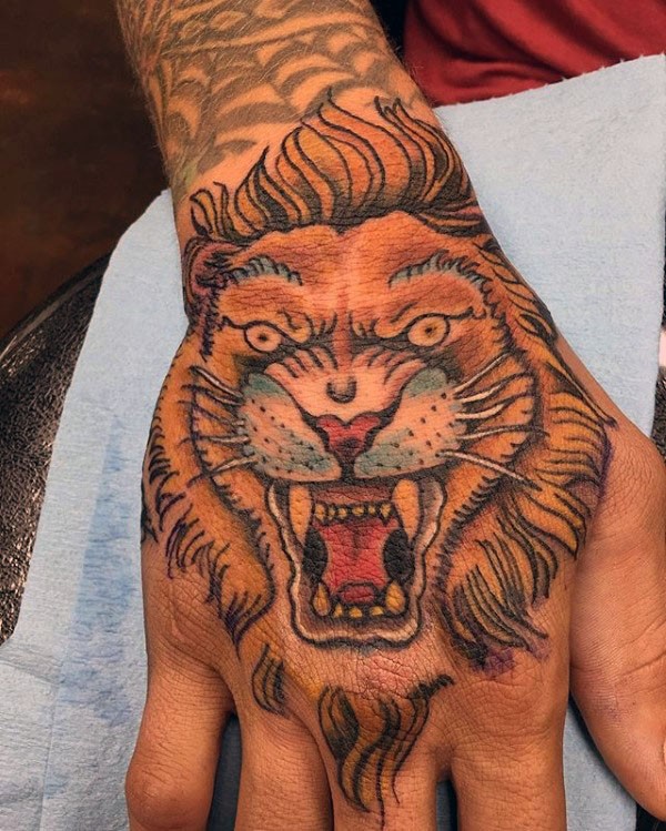 Tatuagem colorida da mão da velha escola do leão demoníaco