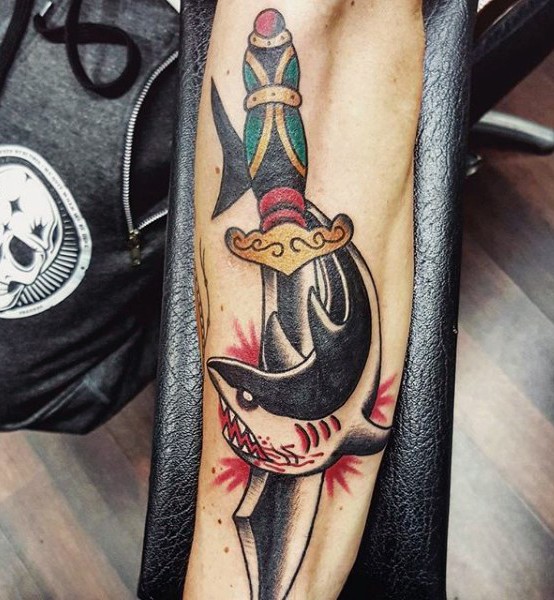 Old school style colored knife with shark tattoo on arm