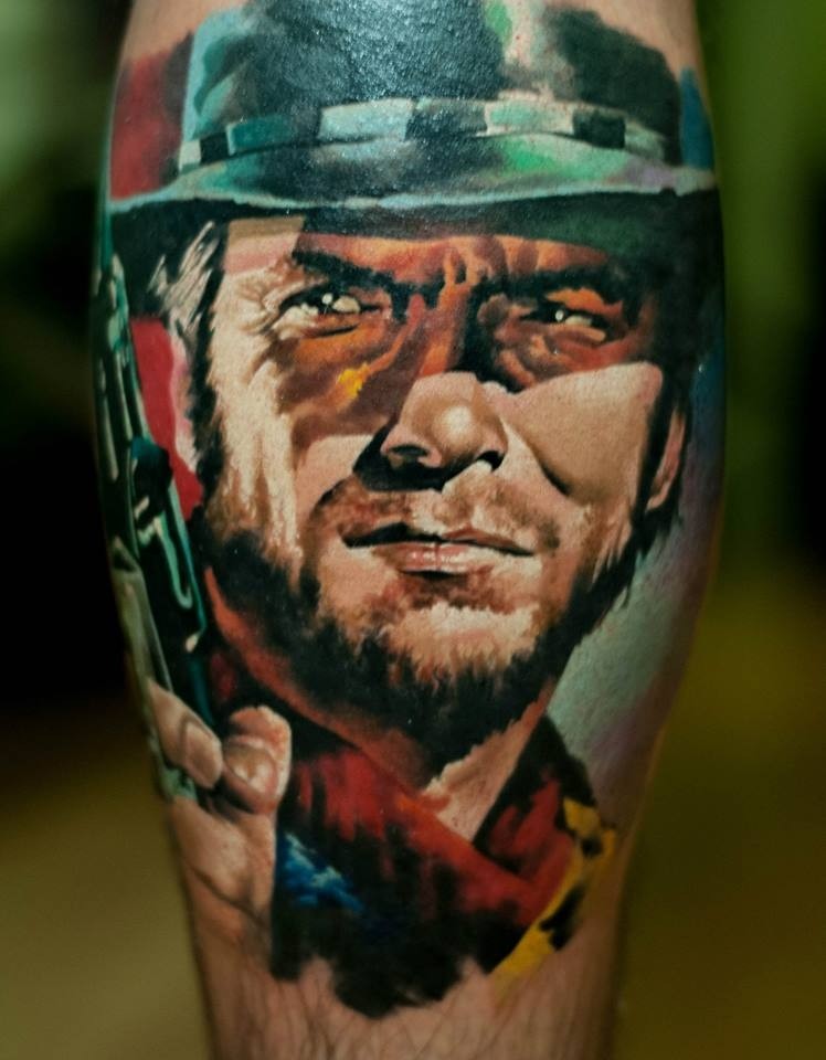 Old school style colored leg muscle tattoo of Clint Eastwood portrait