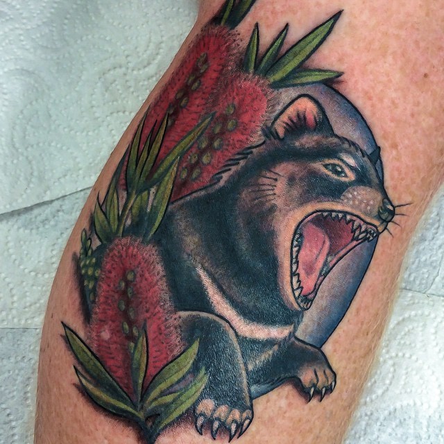 Old school style colored leg tattoo of roaring animal with flowers