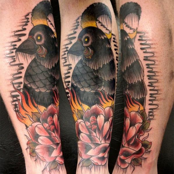 Old school style colored leg tattoo of mystic crow with rose and flames