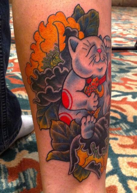 Old school style colored leg tattoo of smiling maneki neko japanese lucky cat with various flowers