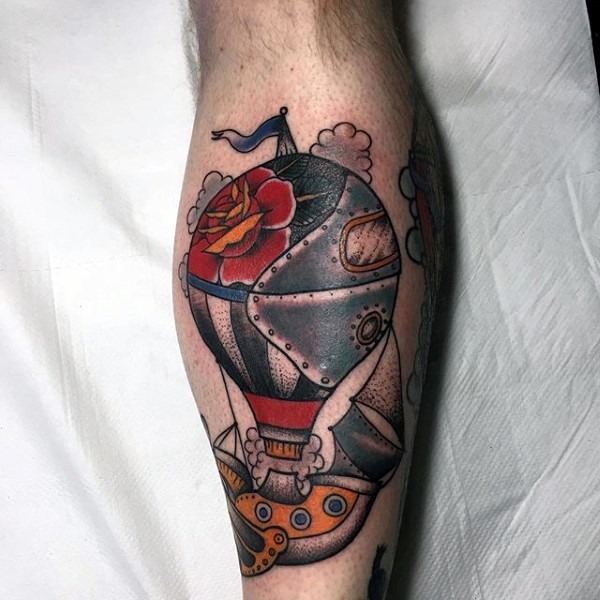 Old school style colored mechanical flying balloon tattoo on leg stylized with red rose