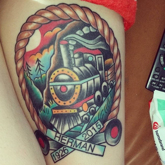 Old school style colored memorial thigh tattoo of train with lettering