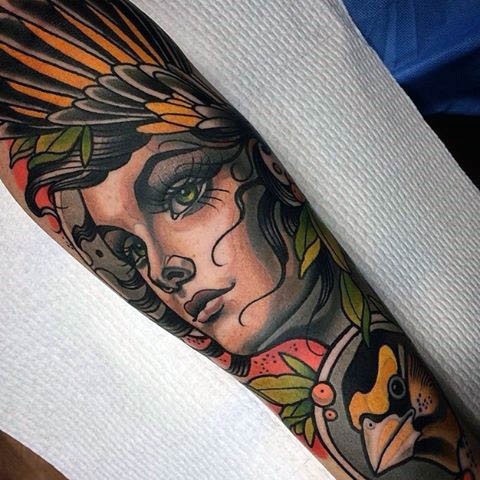 Old school style colored mystical tribal woman tattoo on forearm combined with little bird