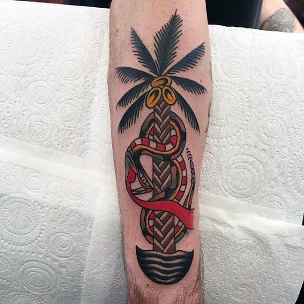 Old school style colored palm tree with snake tattoo on arm