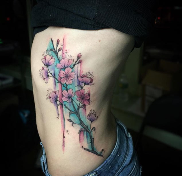 Old school style colored pink flowers tattoo on side