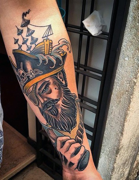 Old school style colored pirate with ship portrait tattoo on arm