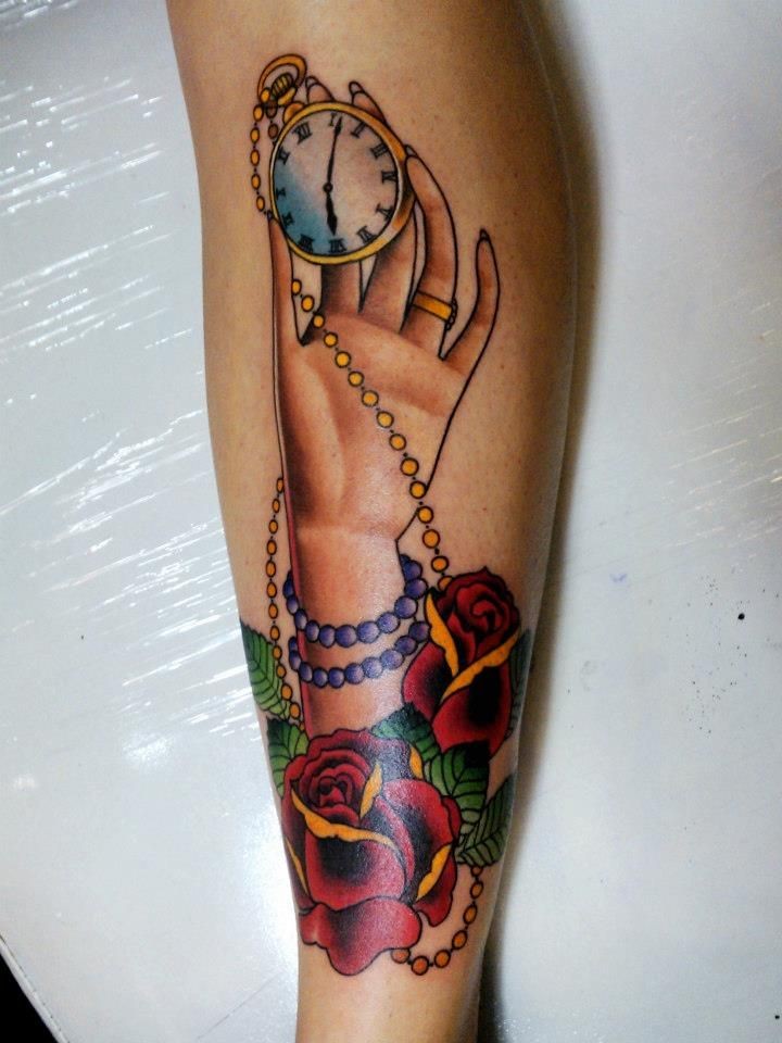Old school style colored tattoo of woman hand with golden clock and flowers