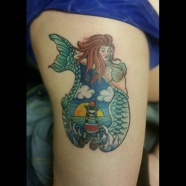 Old school style colored thigh tattoo of mermaid and lighthouse