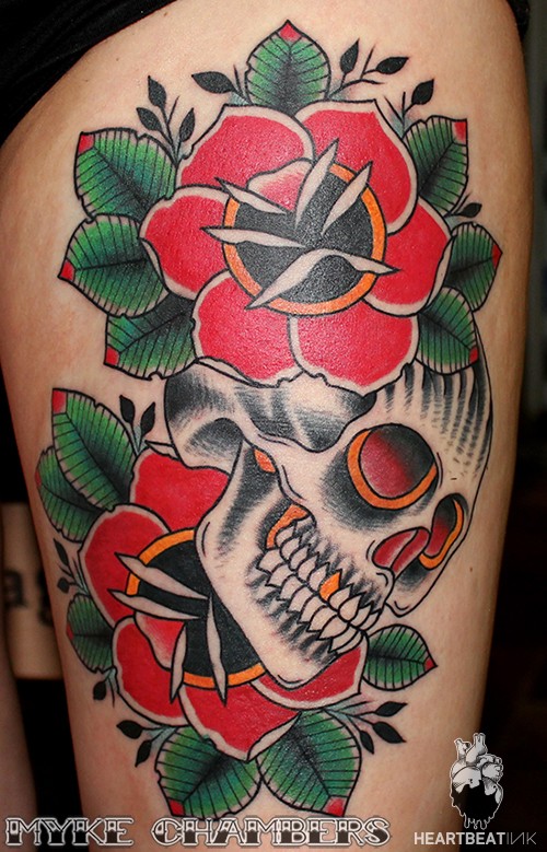 Old school style colored thigh tattoo of typical roses and human skull