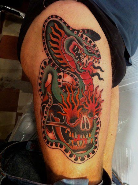 Old school style colored thigh tattoo of big snake with human skull with burning eyes