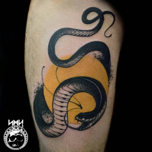 Old school style colored thigh tattoo of snake with yellow circle