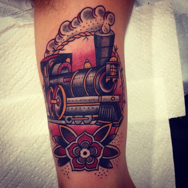Old school style colored train tattoo on biceps with flower