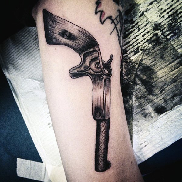 Old school style detailed antic revolver tattoo on forearm