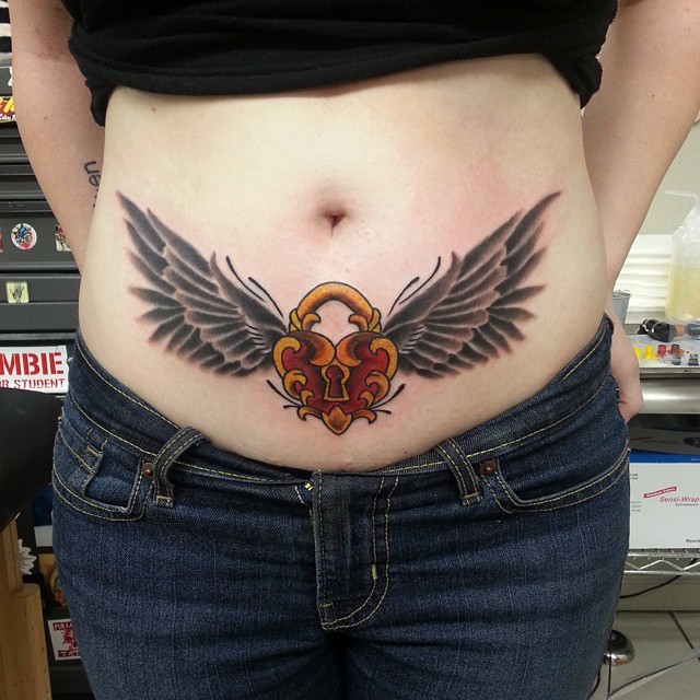 Old school style heart shaped lock with dark wings tattoo on lower belly in old school style