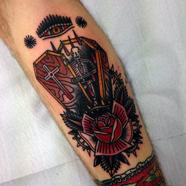 Old school style multicolored coffin with skeleton and flowers tattoo on leg