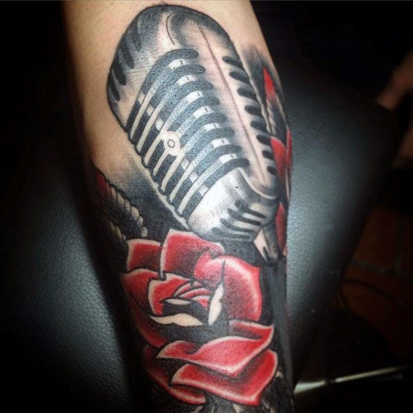 Old school style painted and colored microphone with flower tattoo on arm