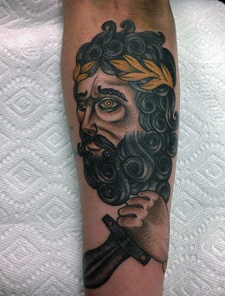 Old school style painted and colored man with dagger tattoo on arm