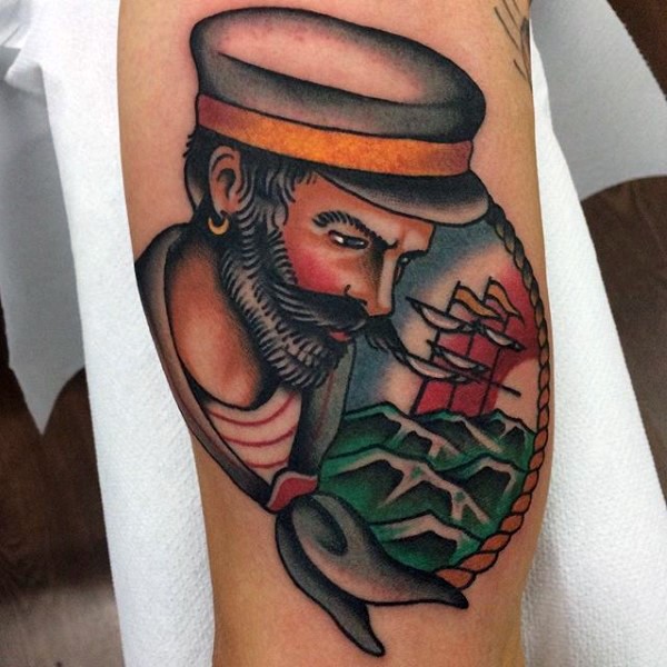 Old school style painted and colored old sailor with ship portrait tattoo on arm