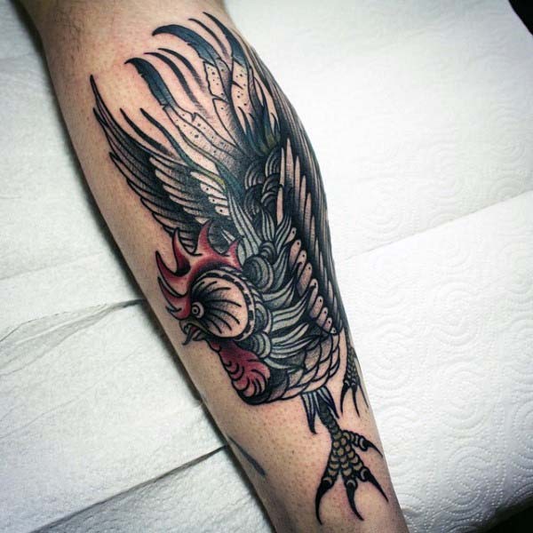 Old school style painted colored angry cock tattoo on leg