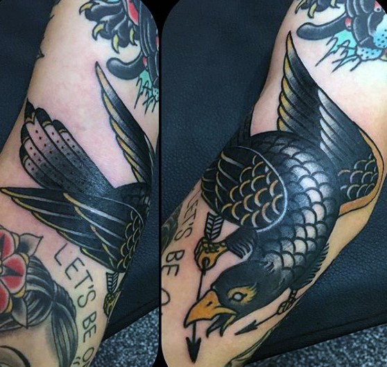 Tatuaje en el brazo,
cuervo peligroso con flechas