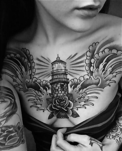 Old school style painted lighthouse tattoo on chest with flower and big waves