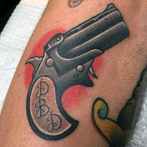 Old school style starting pistol colored tattoo with initial letters