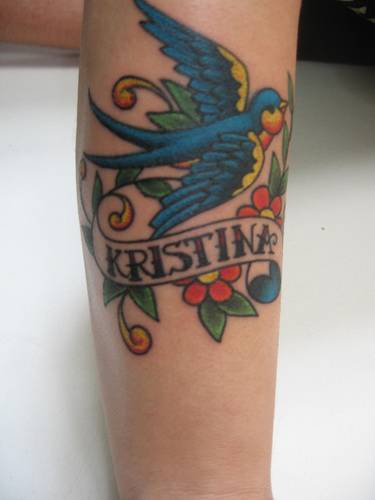 Tatuaje en color con pájaro y una inscripción