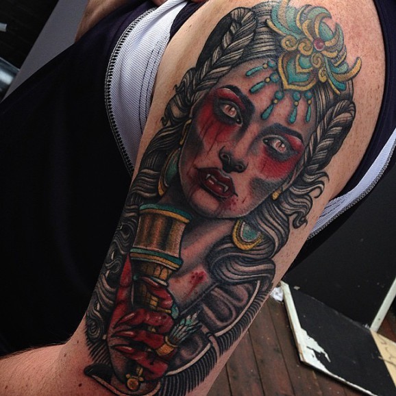 Old school vampiress with goblet of blood tattoo on shoulder