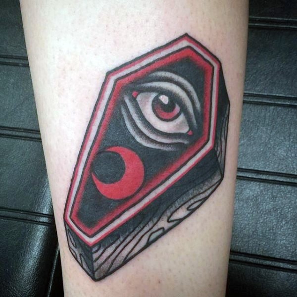 Tatuaje en la pierna, ataúd de madera con ojo y medialuna