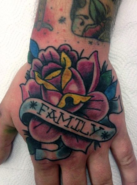 Old style colored rose with lettering family on banner hand tattoo