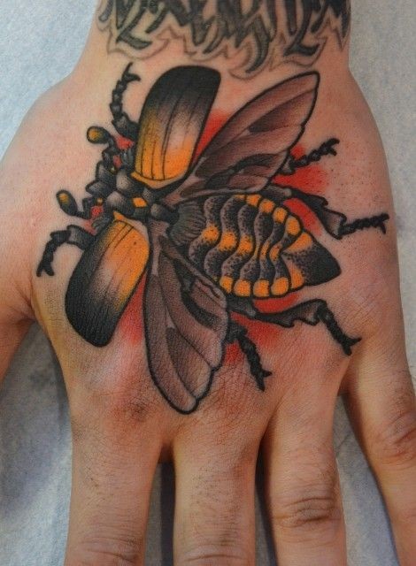 Orange flying bug tattoo on hand